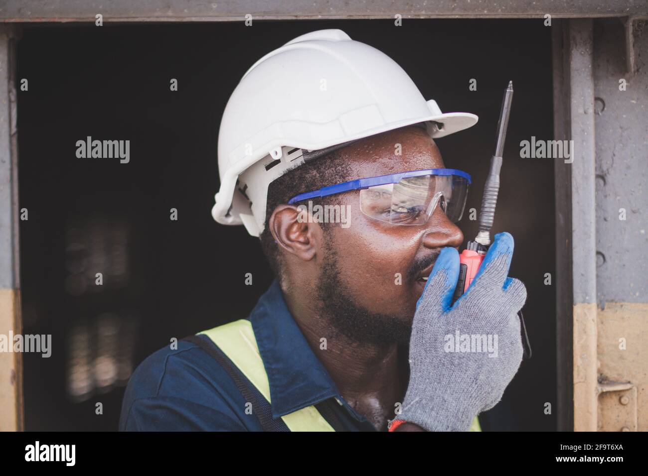 El ingeniero africano masculino controla un con hablar por radio  comunicación o walkie-talkie Fotografía de stock - Alamy