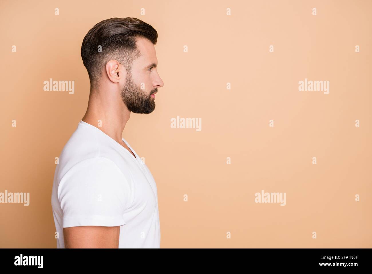 Perfil foto lateral de joven guapo hombre seguro parecer vacío espacio  aislado sobre fondo de color beige Fotografía de stock - Alamy