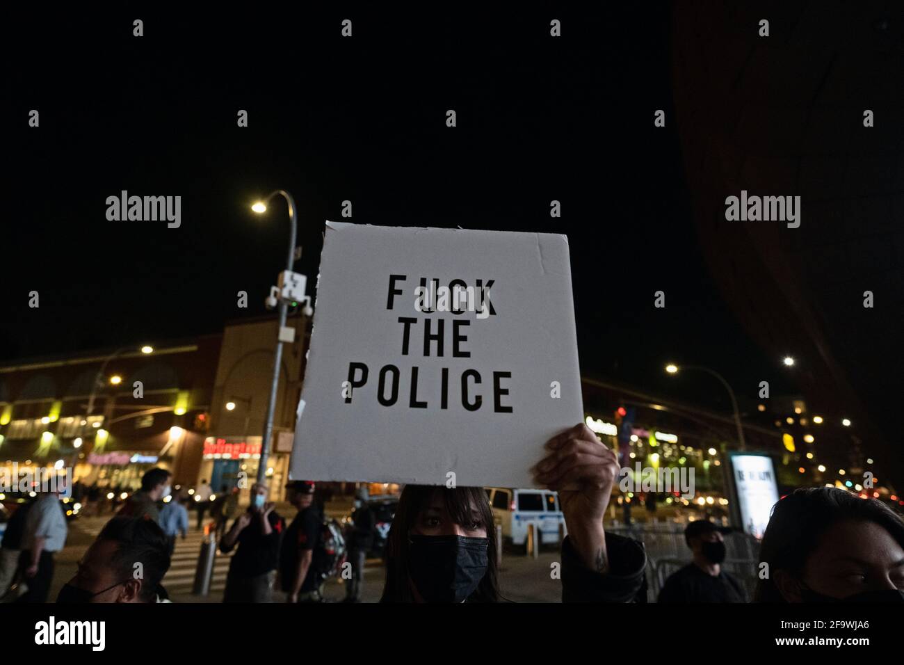 Brooklyn, Nueva York, EE.UU. 20 de abril de 2021. Una mujer sostiene un signo anti-policía mientras los manifestantes se reúnen en el Centro Barclays horas después de que un jurado encontró al ex oficial de policía de Minneapolis Derek Chauvin culpable de asesinar a George Floyd en 2020. Foto de stock