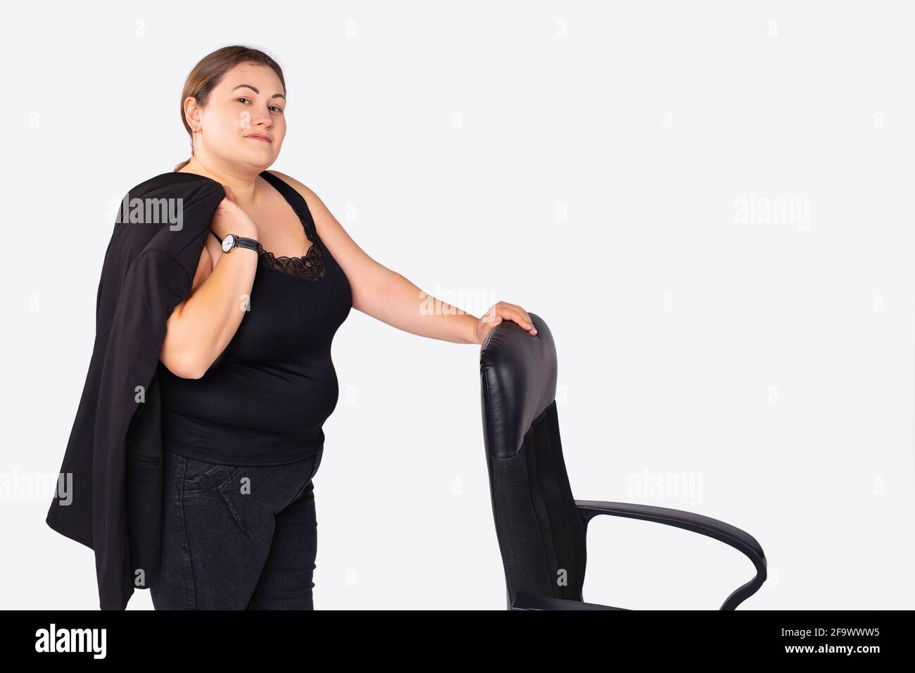 Foto de la dama de negocios bastante segura éxito más el tamaño, mujer  grande. Mujer directa mostrando silla vacía a su trabajo ropa de oficina  blazer pantalón traje Fotografía de stock -