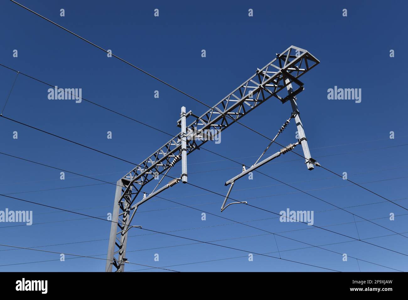 Pilón de alta tensión del ferrocarril contra el cielo azul, Reino Unido Foto de stock