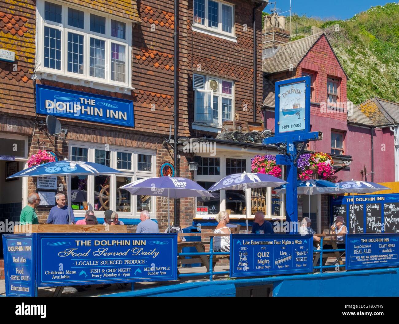 Idea de estatificación. Personas sentadas bajo sombrillas en la terraza del  pub Dolphin Inn en un soleado día de verano en Hastings, East Sussex,  Inglaterra, Reino Unido Fotografía de stock - Alamy