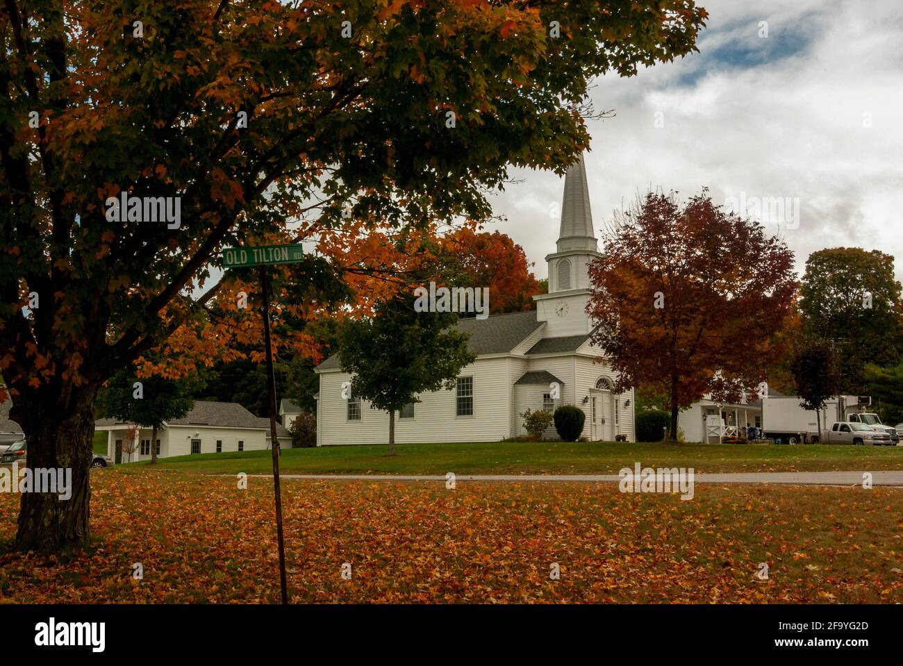 La iglesia comunitaria unida de Canterbury, de madera blanca, New Hampshire, EE.UU., entre las hojas caídas y el follaje rojo en otoño / otoño Foto de stock