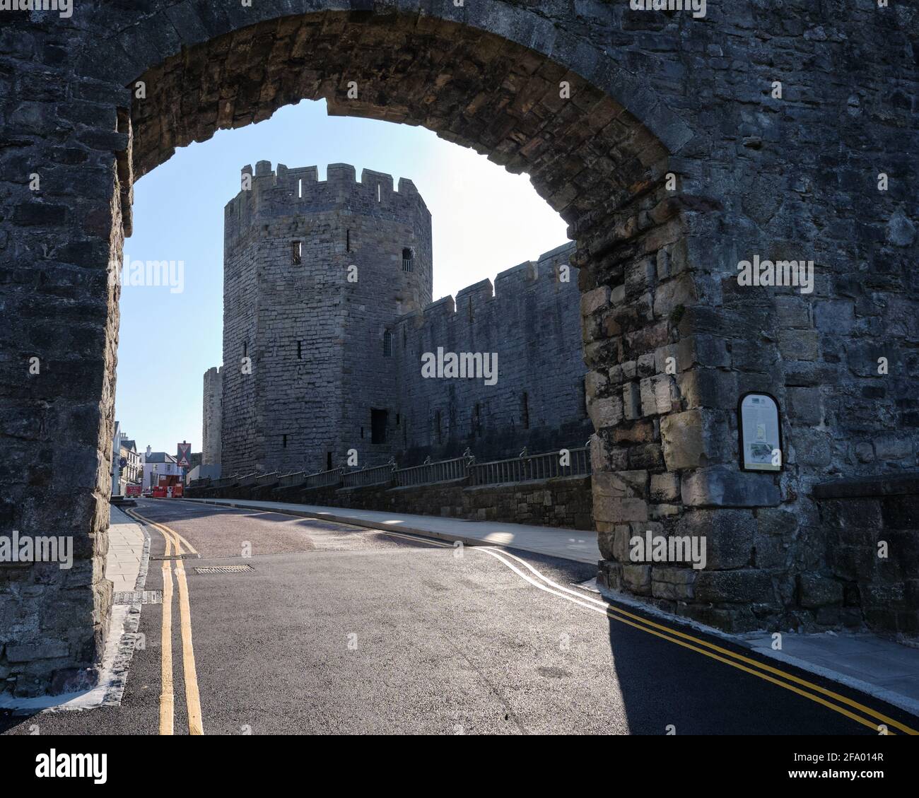 La torre del pozo del castillo de Caernarfon a través de un arco en El Muro de la Ciudad Foto de stock