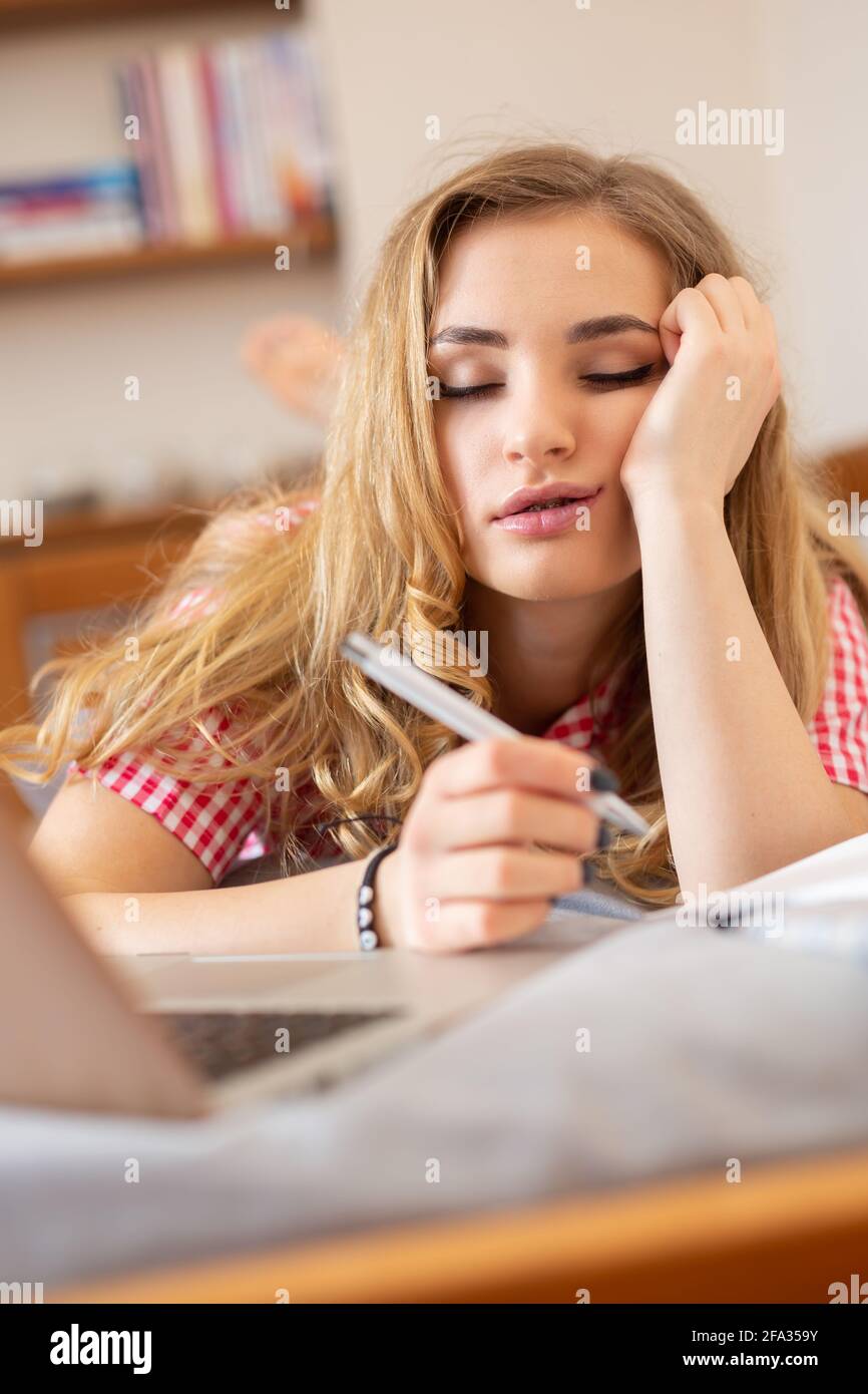 Chica rubia aburrida estudiando fotografías e imágenes de alta