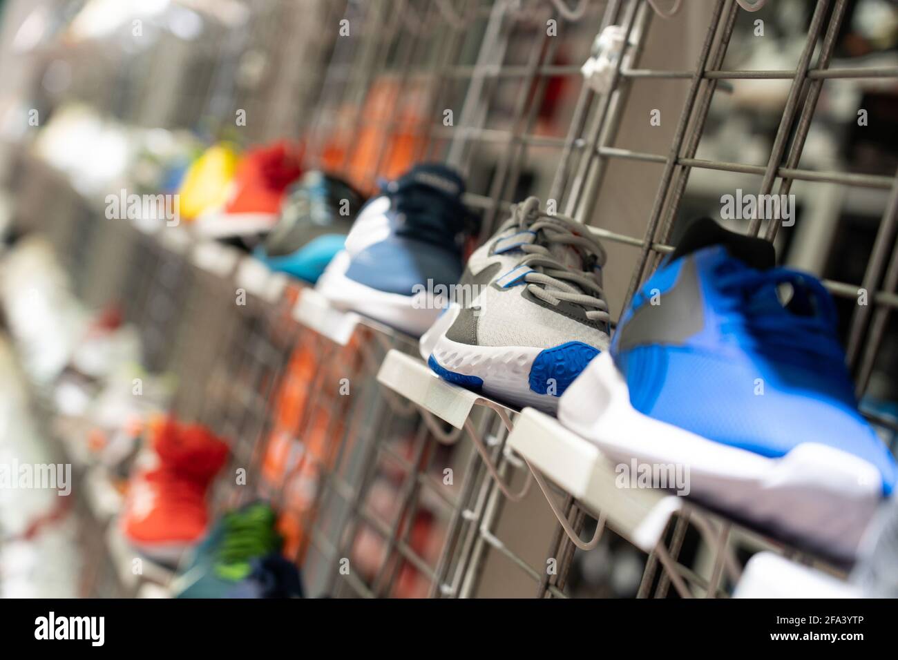Cremallera con zapatillas deportivas en las estanterías de la tienda de  sneakers. Enfoque selectivo. Muchos zapatos deportivos se venden en la  estantería en un supermercado, como fondo de efecto borroso Fotografía de