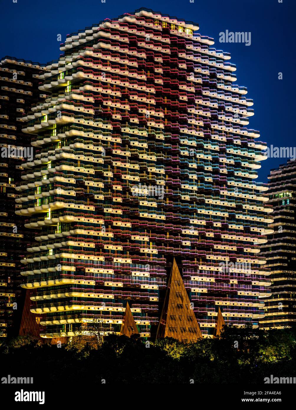Sanya China , 25 de marzo de 2021 : Vista vertical de uno de los edificios del hotel Beauty Crown Grand Tree iluminado por la noche en la ciudad de Sanya, en la isla C de Hainan Foto de stock