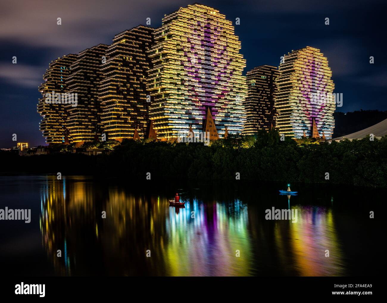 Sanya China , 25 de marzo de 2021 : Hermosa vista del hotel Beauty Crown Grand Tree, coloridos edificios conocidos como el hotel Lego Trees iluminado por la noche con agua Foto de stock