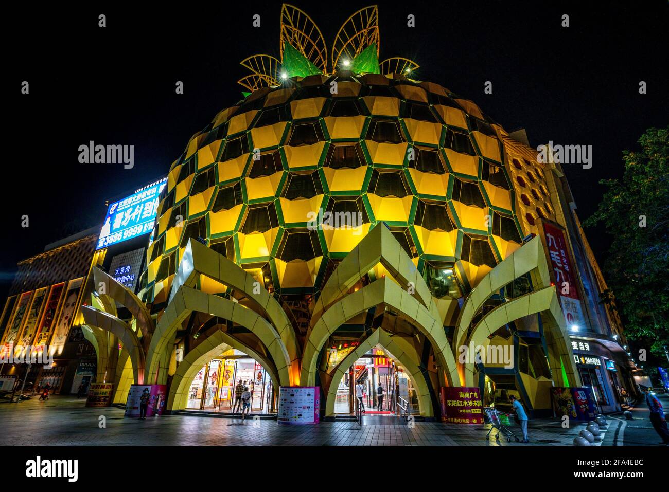 Sanya China , 25 de marzo de 2021 : Vista frontal del centro comercial Pineapple iluminada por la noche en un centro comercial en la zona de Dadonghai, en la ciudad de Sanya, en la isla de Hainan, China Foto de stock