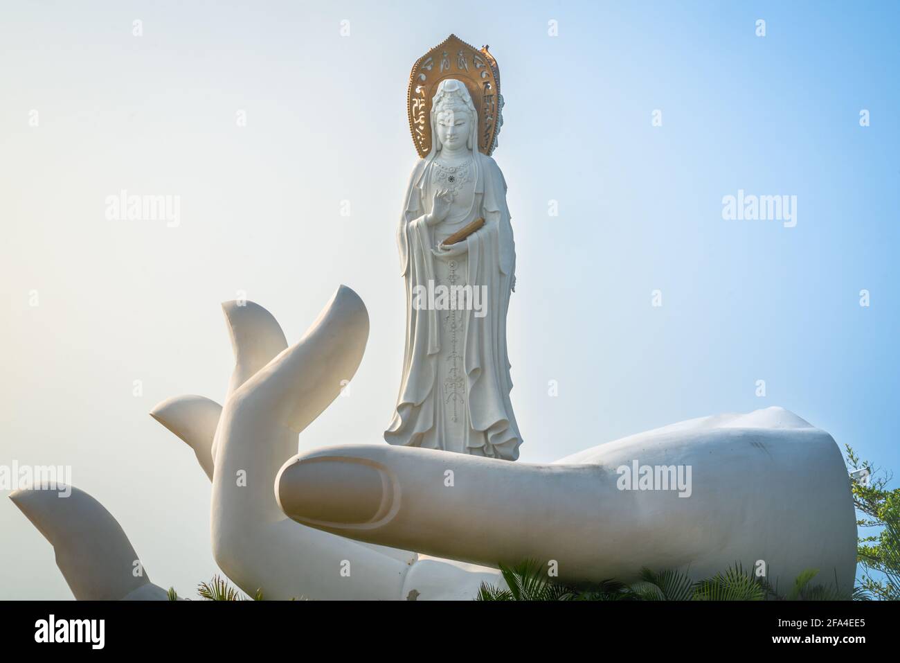 Blanco a mano abierta con la estatua de Guanyin del Mar del Sur Encima de él en el templo del parque cultural del budismo de Nanshan En Sanya, en la isla de Hainan, China Foto de stock