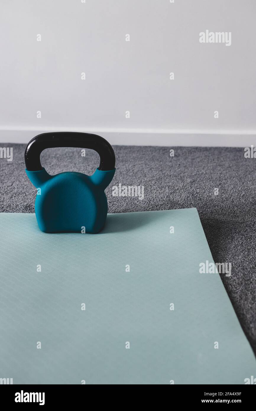 gimnasio casero con artículos de gimnasia mixtos, incluyendo colchoneta de  yoga y kettlebell con sutiles tonos grises y azules Fotografía de stock -  Alamy