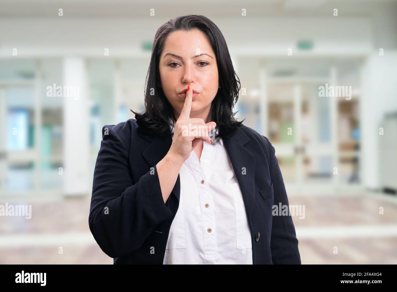 Mujer de negocios seria con traje elegante sport que hace un gesto de rubor  con indexe el dedo como concepto corporativo en el fondo de la oficina  Fotografía de stock - Alamy
