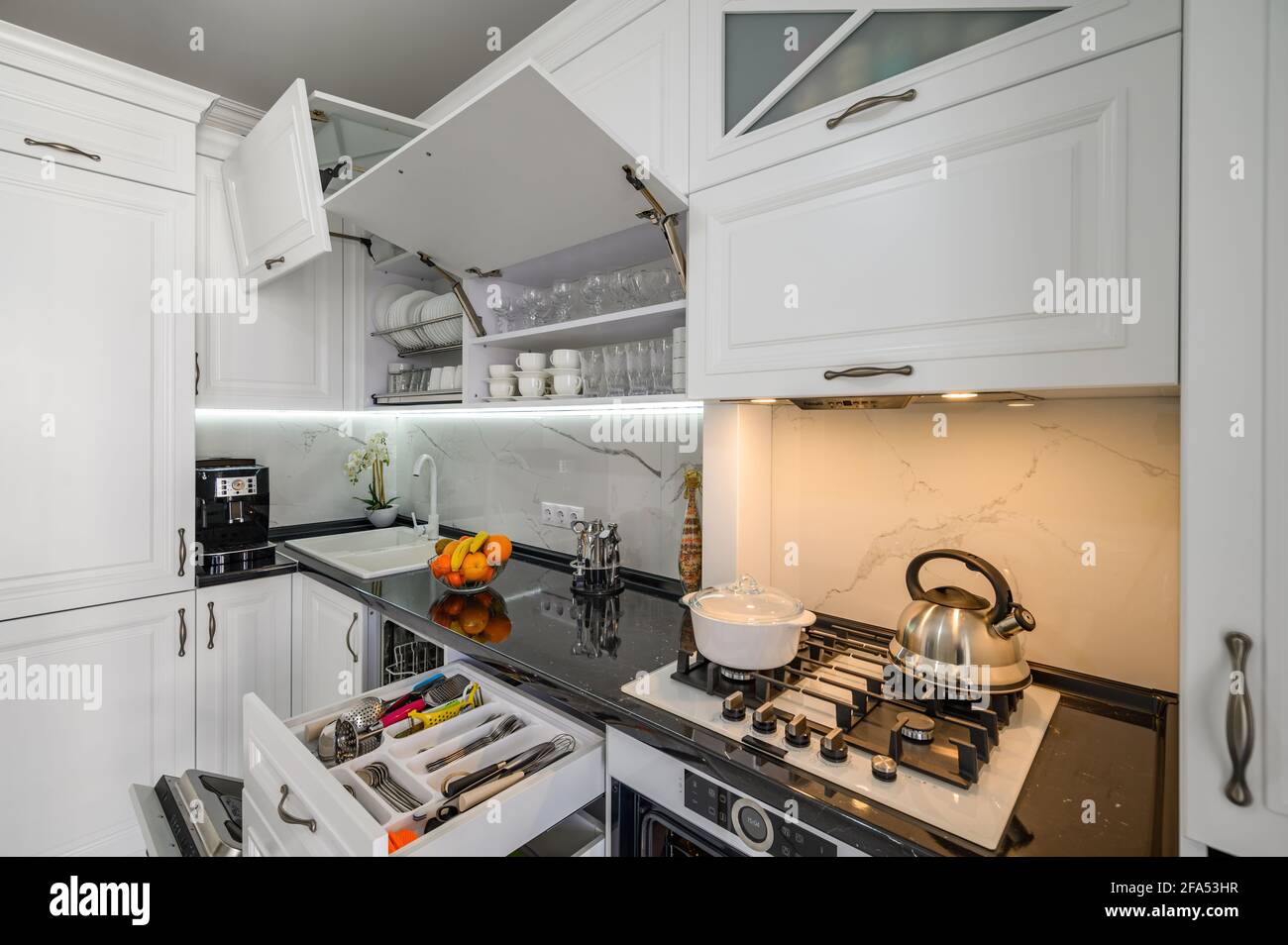 Interior de cocina moderna, blanca y lujosa, cajones extraídos, puertas  abiertas Fotografía de stock - Alamy