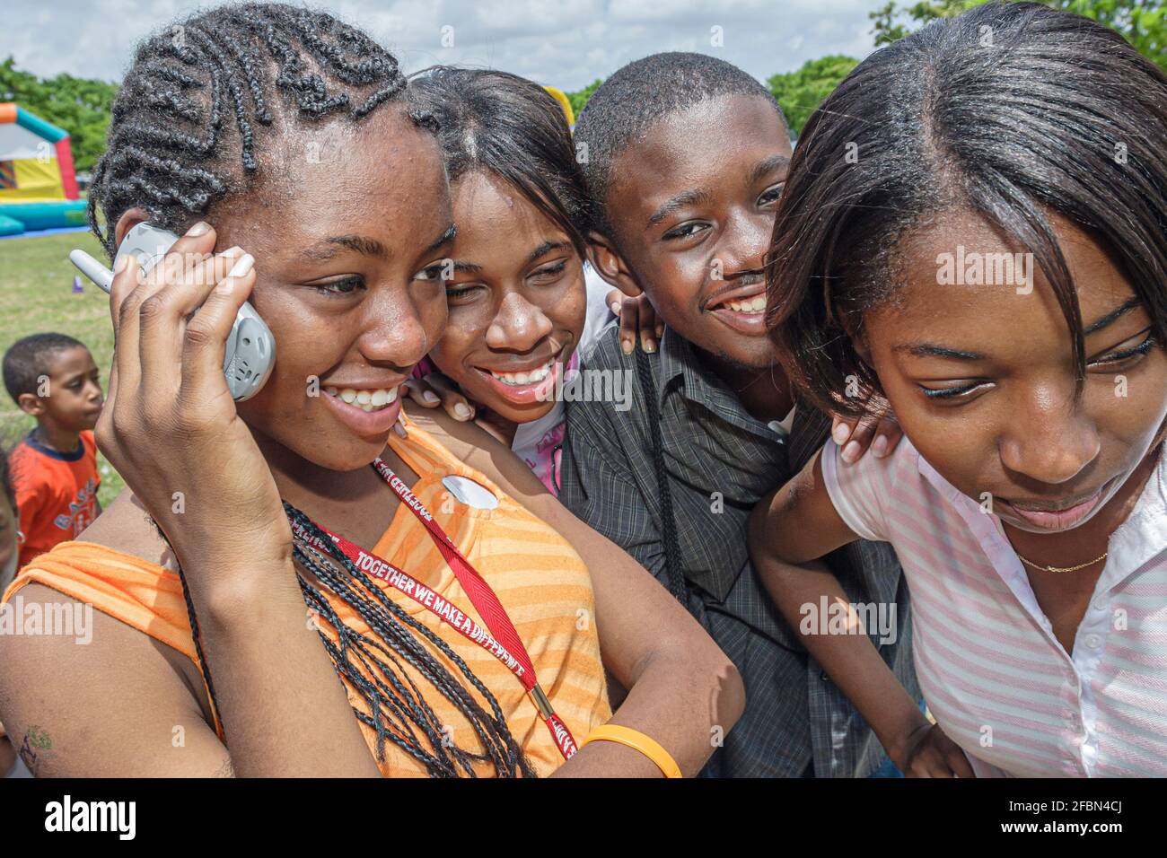 Miami Florida, Tropical Park Drug Free Youth in Town DFYIT, picnic de grupo contra la adicción de estudiantes adolescentes, adolescentes negros usando teléfono celular teléfono móvil phon Foto de stock