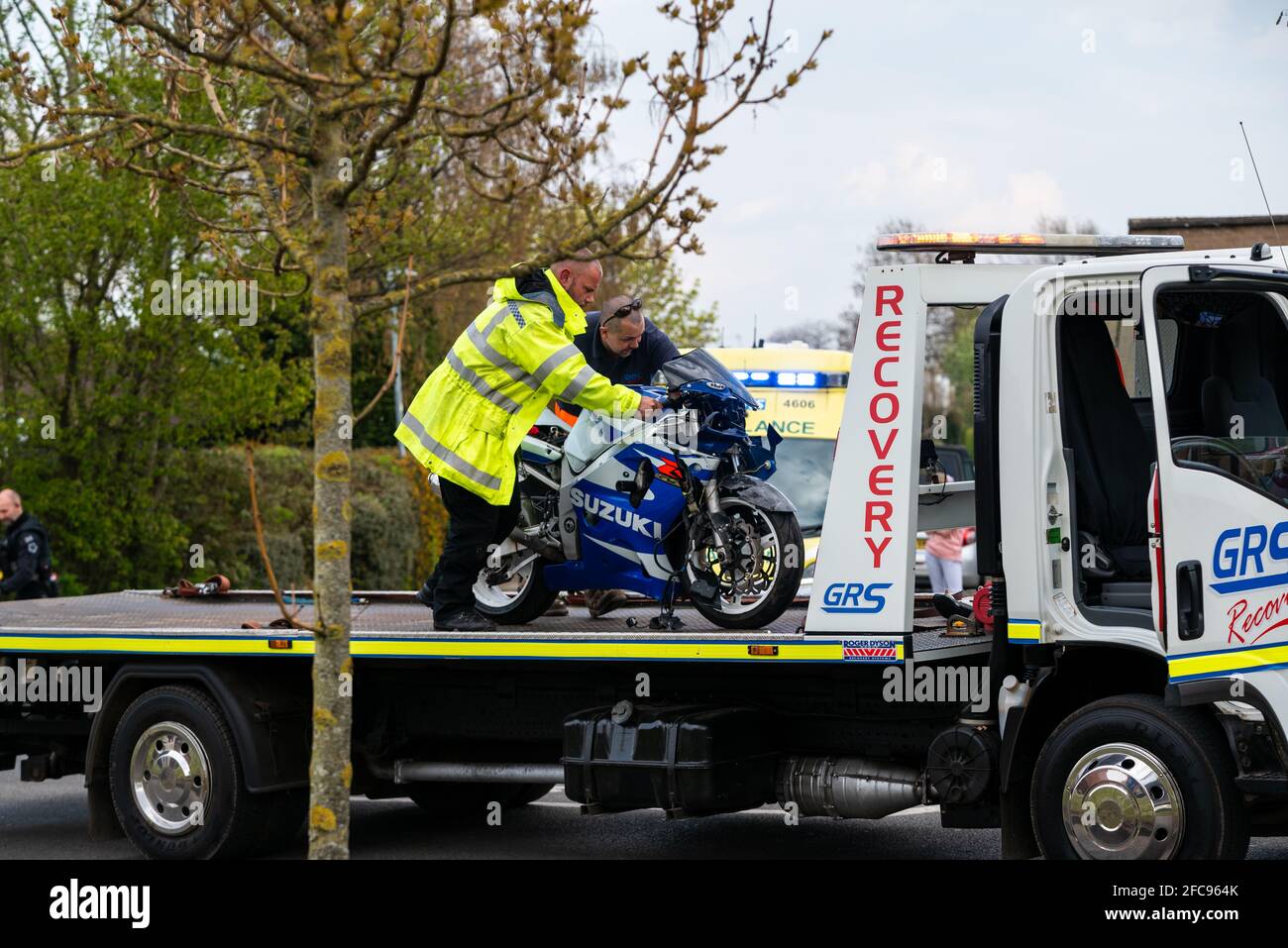 Oficial de policía cargando una moto Suzuki en un camión de recuperación después de una colisión de tráfico en Leamington Spa, Reino Unido. Policía de Warwickshire. Foto de stock