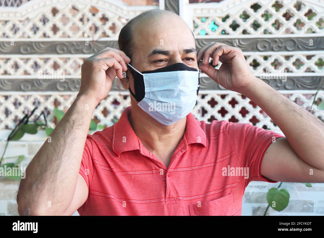 doble máscara prevenir la infección, hombre indio maduro usando dos máscara facial para proteger de la nueva cepa de coronavirus o nueva ola de covid-19 brote en i Foto de stock