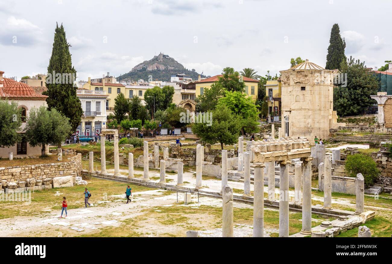 Atenas – 6 de mayo de 2018: Los turistas visitan Ágora romana en Atenas, Grecia. Panorama de las ruinas griegas antiguas en el distrito de Plaka en el centro de la ciudad de Atenas. Torre vieja Foto de stock