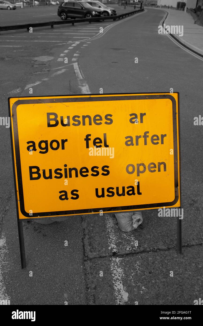 El negocio abre como señal habitual, en inglés y galés, advirtiendo de las obras de carretera por delante. Con color selectivo Foto de stock