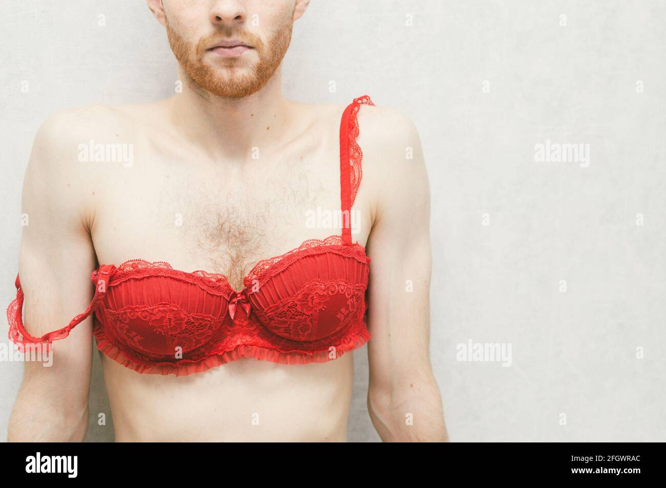 Hombre joven en un sujetador rojo de mujer. Gay Fotografía de stock - Alamy