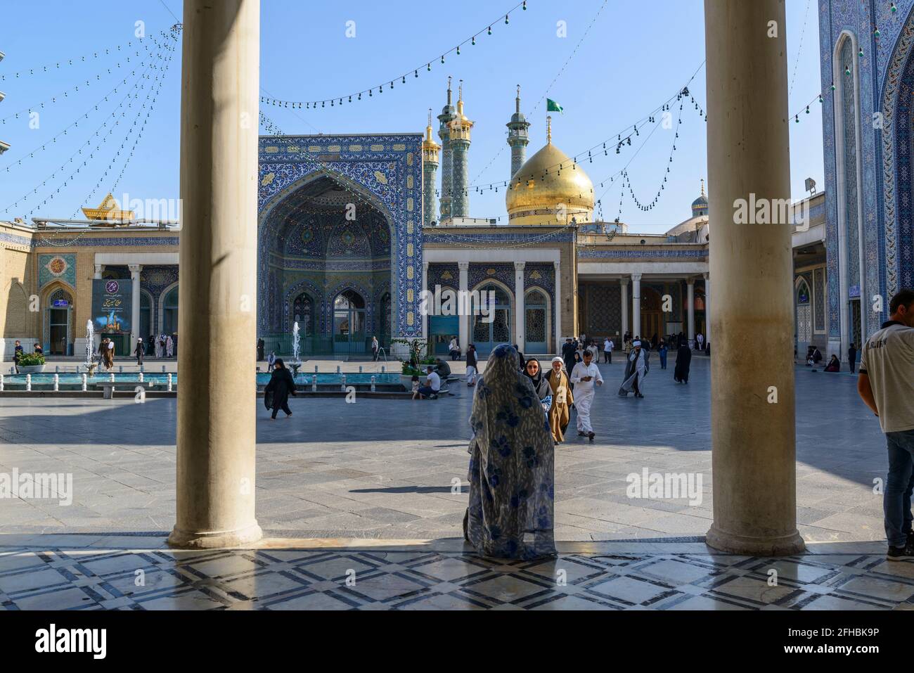 Qom, Irán:El patio de la mezquita Azam, junto al santuario santo de Fátima Masumeh (la cúpula dorada) . Foto de stock