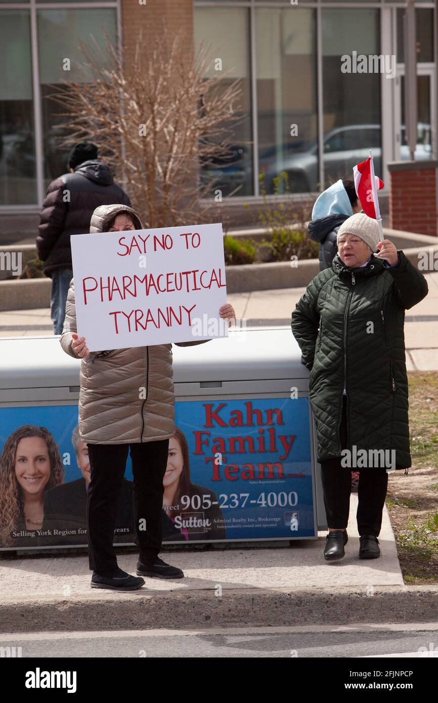 Vaughan, Canadá - 25 de abril de 2021: Mujeres holding decir no a la tiranía farmacéutica signo en protesta de las medidas de cierre COVID-19 en Ontario Foto de stock