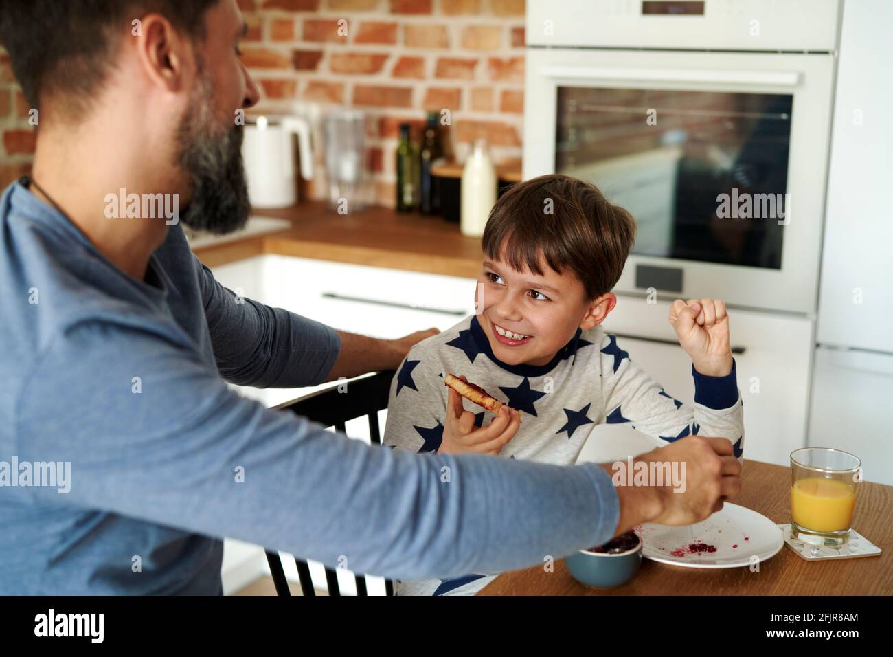 Mitad hombre adulto desayunando con su hijo Foto de stock