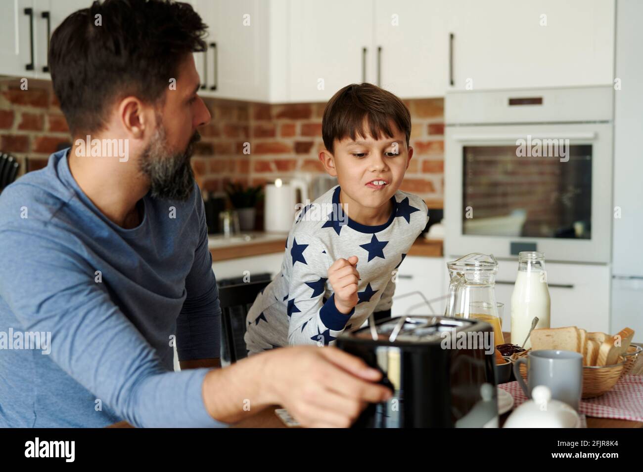 Padre e hijo desayunando por la mañana Foto de stock