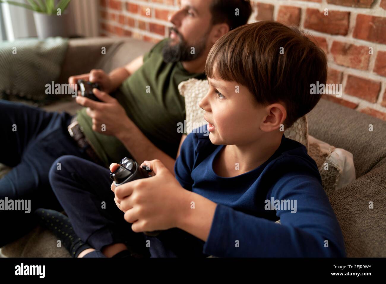 Padre e hijo jugar video juego en casa Foto de stock