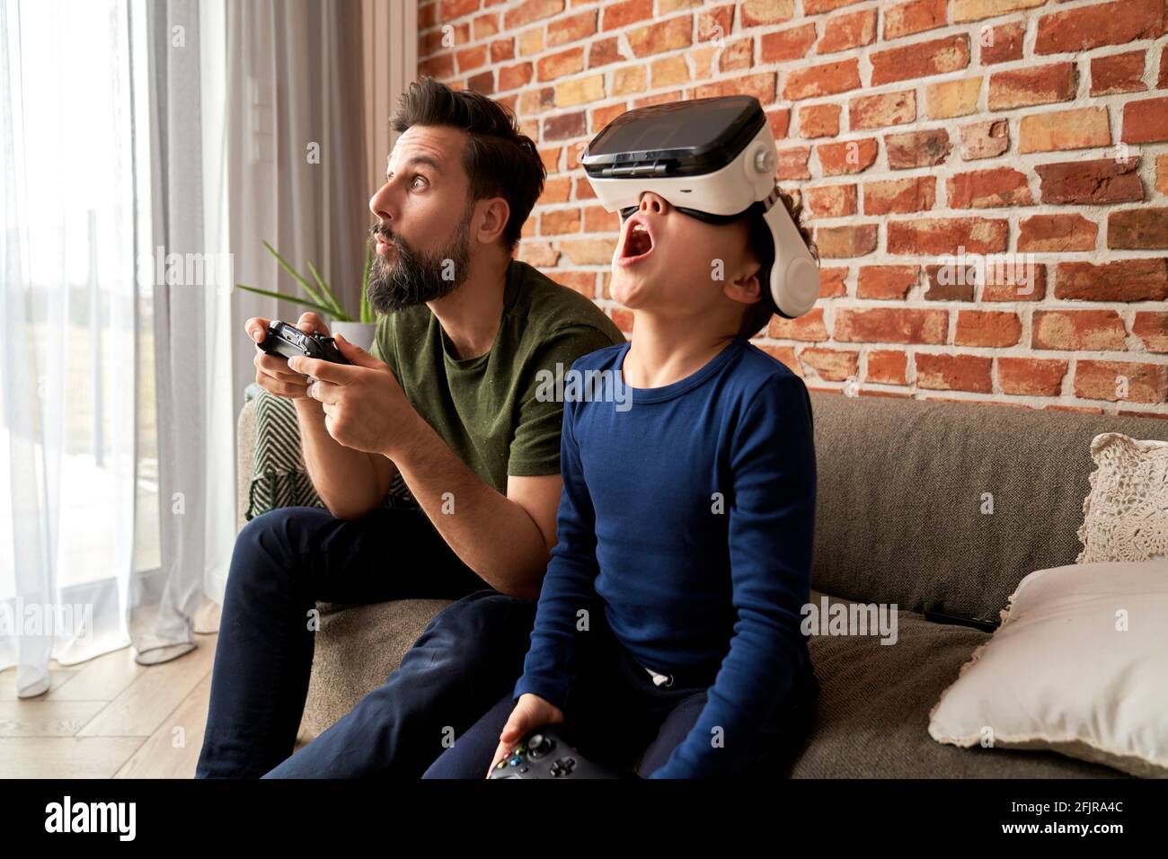 Padre e hijo pasan tiempo juntos jugando a videojuegos Foto de stock