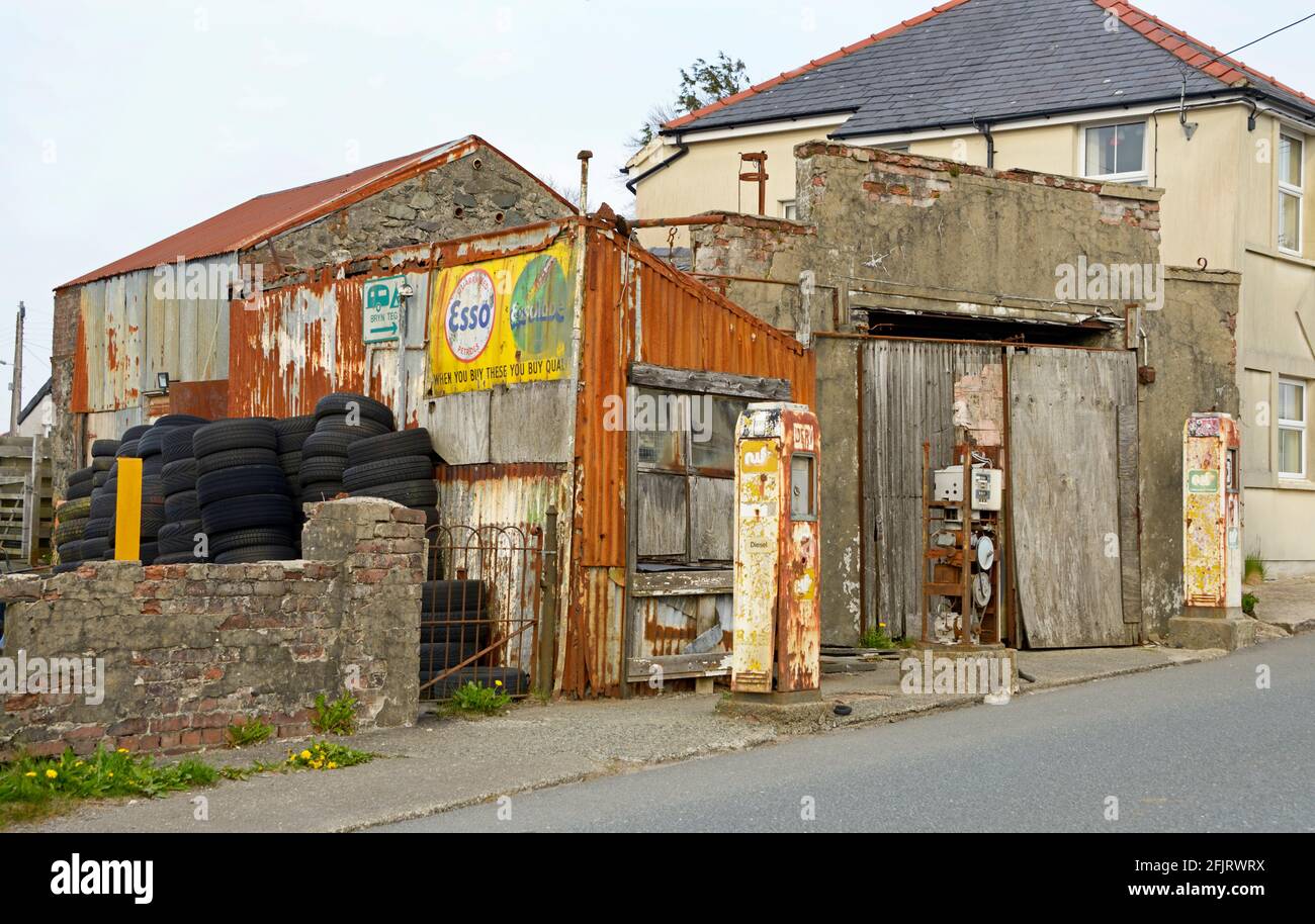 Garaje antiguo con bombas y letreros oxidados, en Gales. Foto de stock