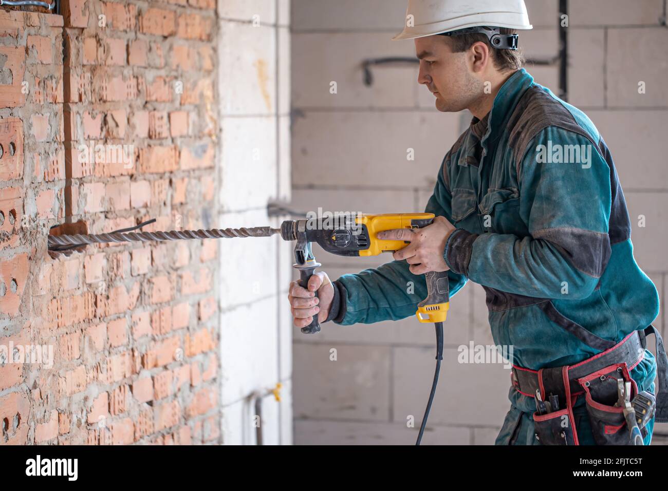 Hombre de mano en el proceso de perforar una pared con una perforadora  Fotografía de stock - Alamy