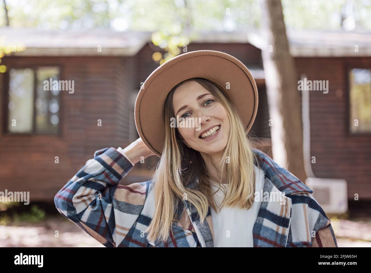 Mujer joven caucásica con estilo de 30-35 años de edad con ropa informal la  camisa y el sombrero vaquero disfrutan de la vida por la mañana durante el  verano aventura en camping