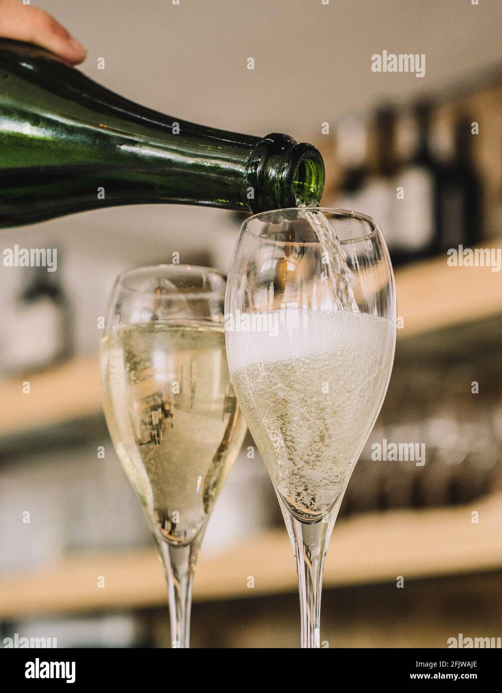 Un camarero que sirve dos copas de champán español Cava de origen catalán Foto de stock
