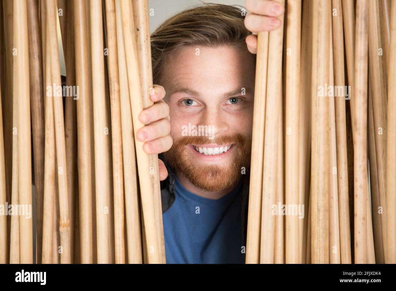 hombre curioso mirando a través del bambous Foto de stock