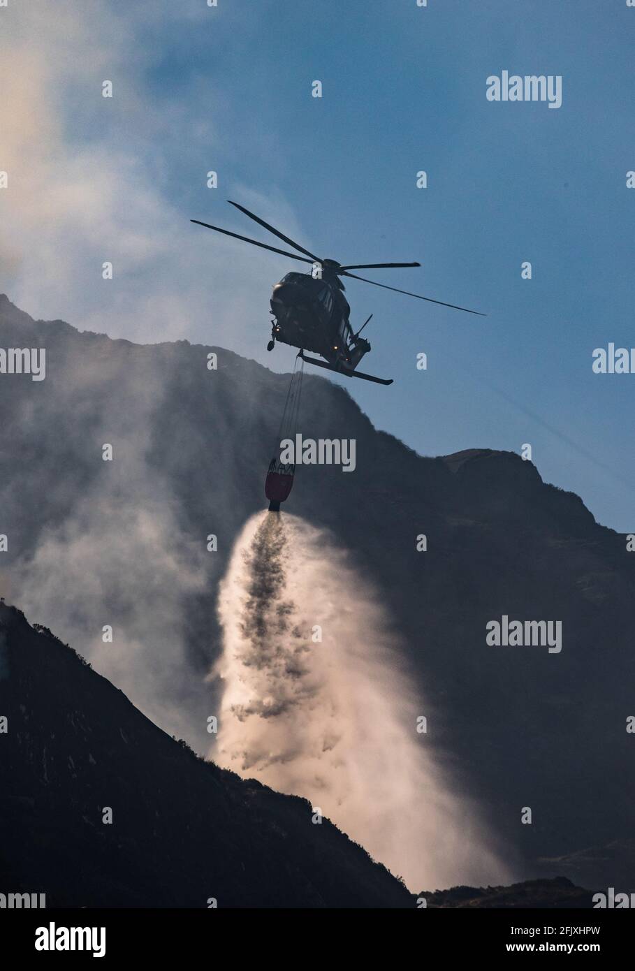 Parque Nacional de Killarney, Irlanda - 26th de abril. 2021: Irish Air Corp Helicopter descarga agua para extinguir el fuego en el Parque Nacional de Killarney Foto de stock