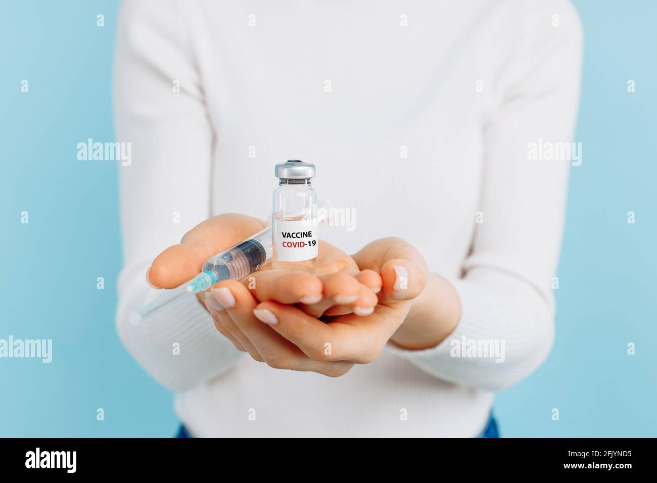 Mujer joven con un frasco de vacuna contra el coronavirus covid-19, médico en un laboratorio con un tubo de ensayo biológico para análisis y muestreo para el i Foto de stock