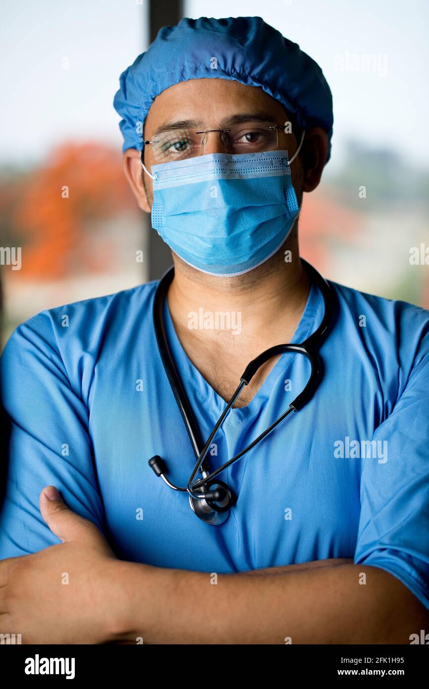 cirujano masculino en mascarilla facial con brazos Foto de stock
