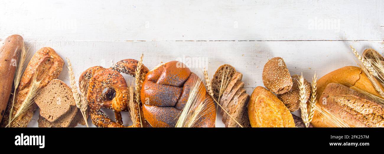 Surtido de deliciosos panes recién horneados, sobre fondo blanco vista superior espacio de copia Foto de stock