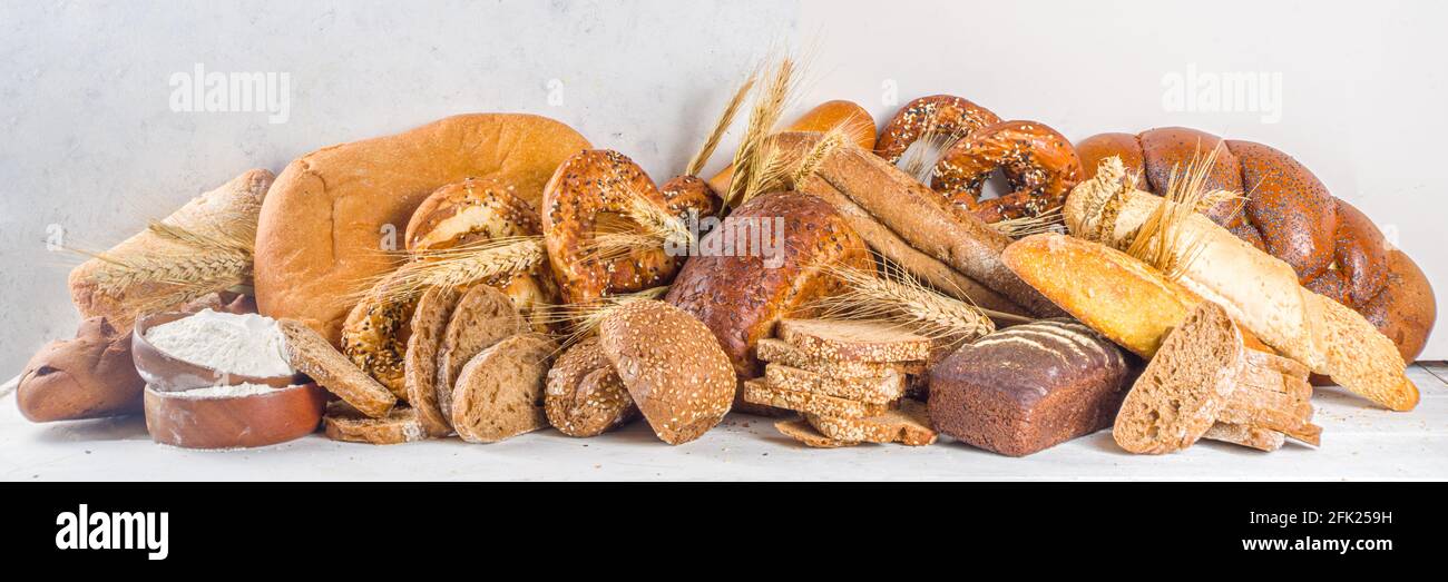 Surtido de deliciosos panes recién horneados, sobre fondo blanco vista superior espacio de copia Foto de stock