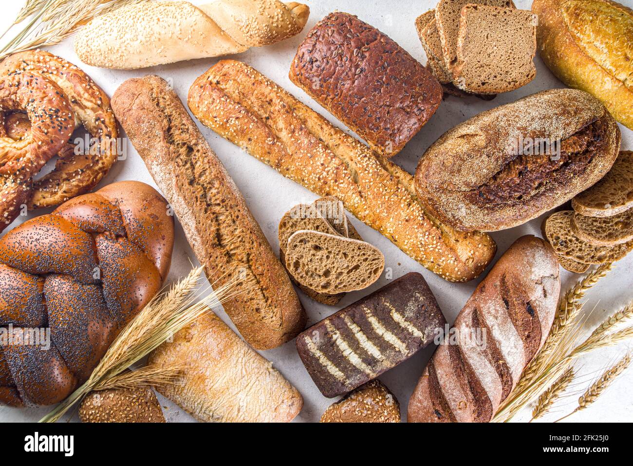 Surtido de deliciosos panes recién horneados, sobre fondo blanco vista superior espacio de copia Foto de stock