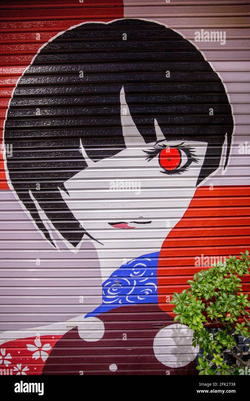 Arte de graffiti fresco de chica japonesa con arte moderno art deco corte de pelo y un ojo rojo. Retrato de anime. Arte callejera en Kobe, Japón. Foto de stock