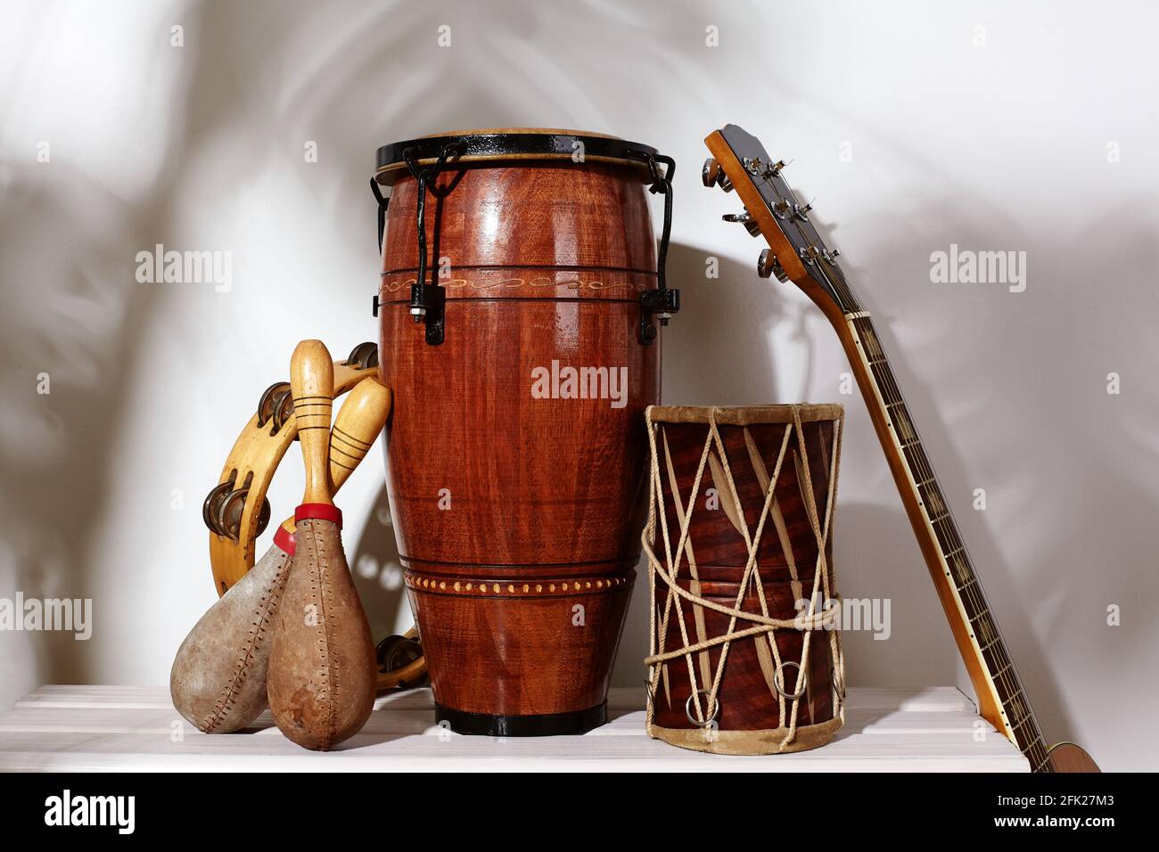 Composición del instrumento étnico musical. Maracas, pandereta, conga,  guitarra y tambor étnico. Instrumentos de percusión rima bajo la sombra de  la palma. Sou cubano Fotografía de stock - Alamy
