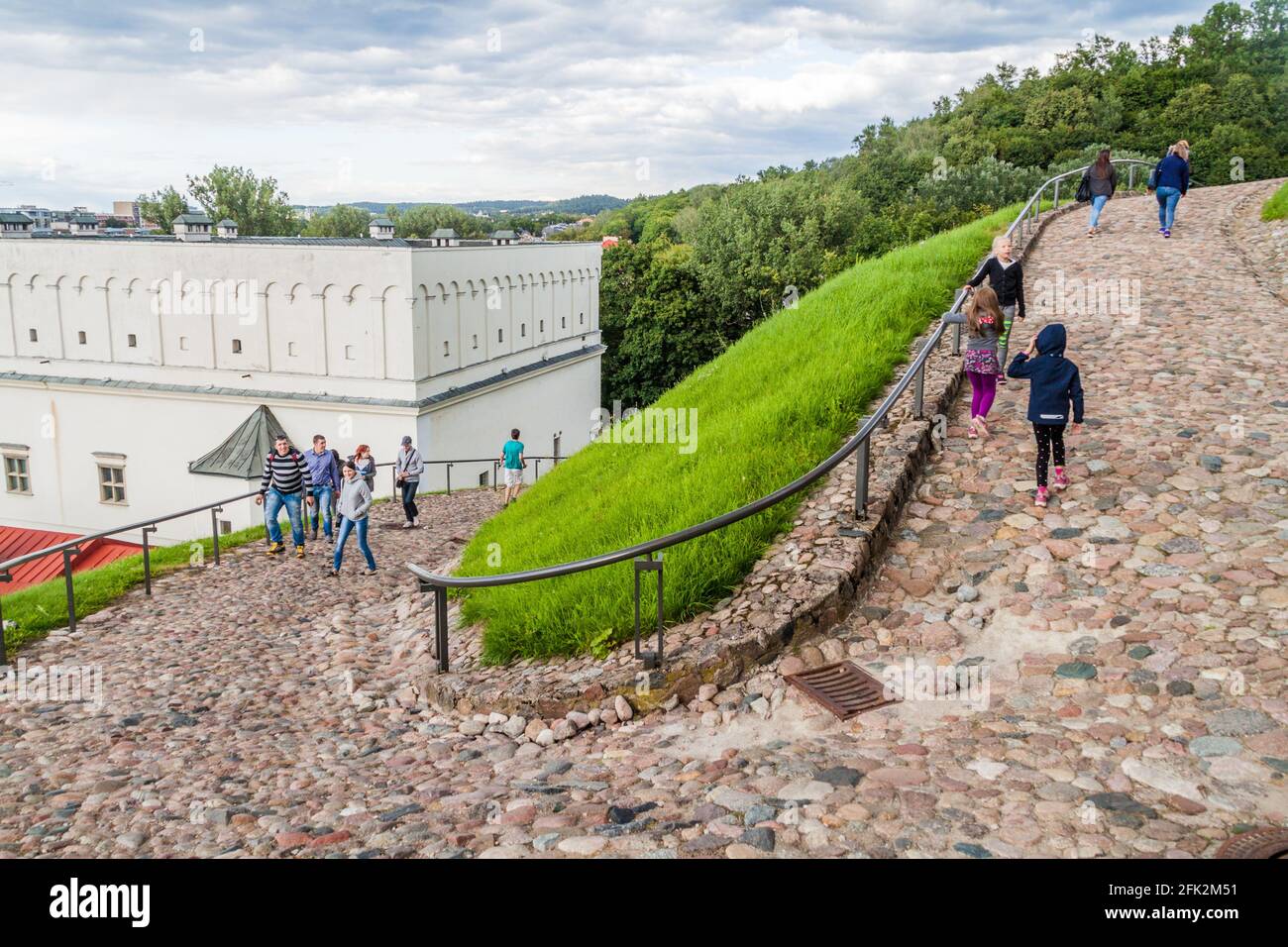 VILNA, LITUANIA - 15 DE AGOSTO de 2016: La gente camina por un camino adoquinado hasta el Castillo Superior de Vilna, Lituania Foto de stock