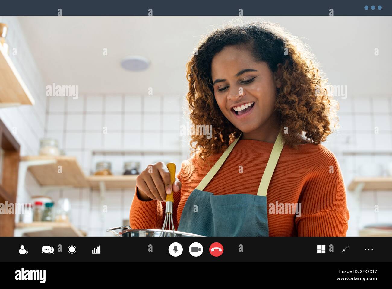 Feliz sonrisa joven afroamericana haciendo videollamada mientras cocina en casa Foto de stock