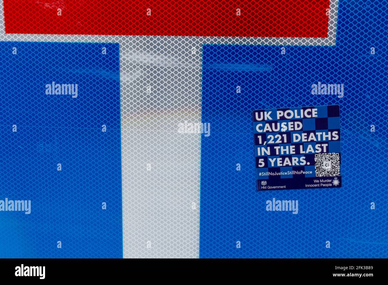 Una pegatina azul contra la policía en una señal de tráfico que afirma que la policía del Reino Unido ha causado 1221 muertes en los últimos cinco años. Foto de stock