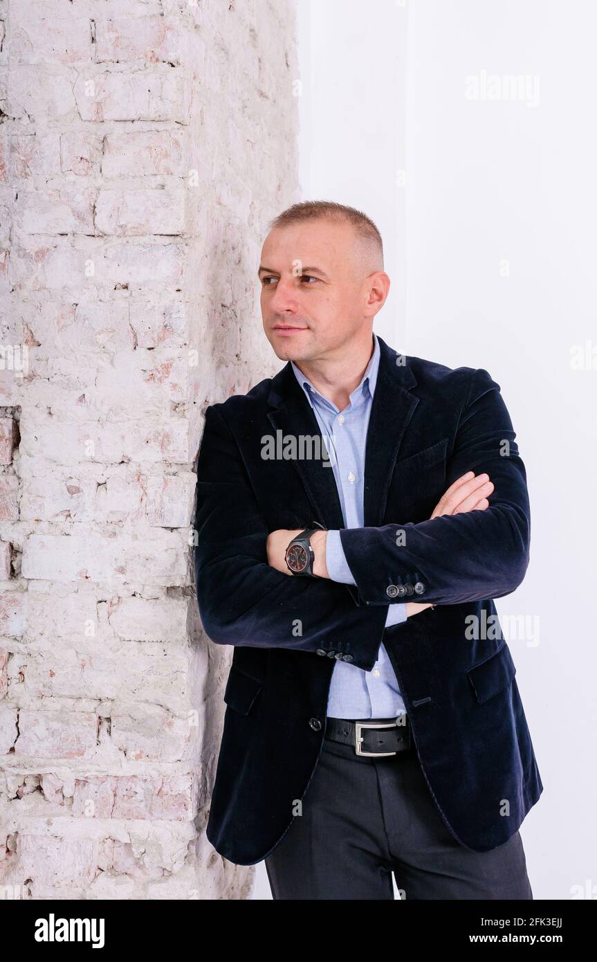 con camisa azul, pantalón negro y chaqueta azul sobre fondo de de ladrillo de stock - Alamy