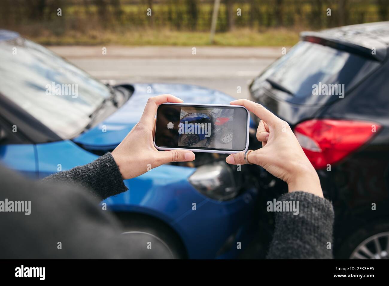 Primer plano de una conductora que toma fotos del tráfico de la carretera accidente en el teléfono móvil para reclamación de seguros Foto de stock