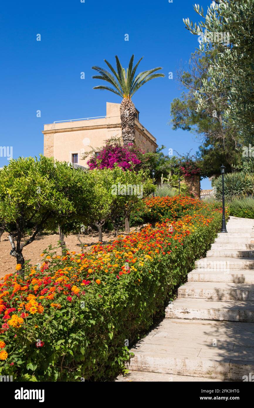 Agrigento, Sicilia, Italia. Jardines del histórico hotel boutique Baglio della Luna, flores coloridas de la común lantana prominente. Foto de stock