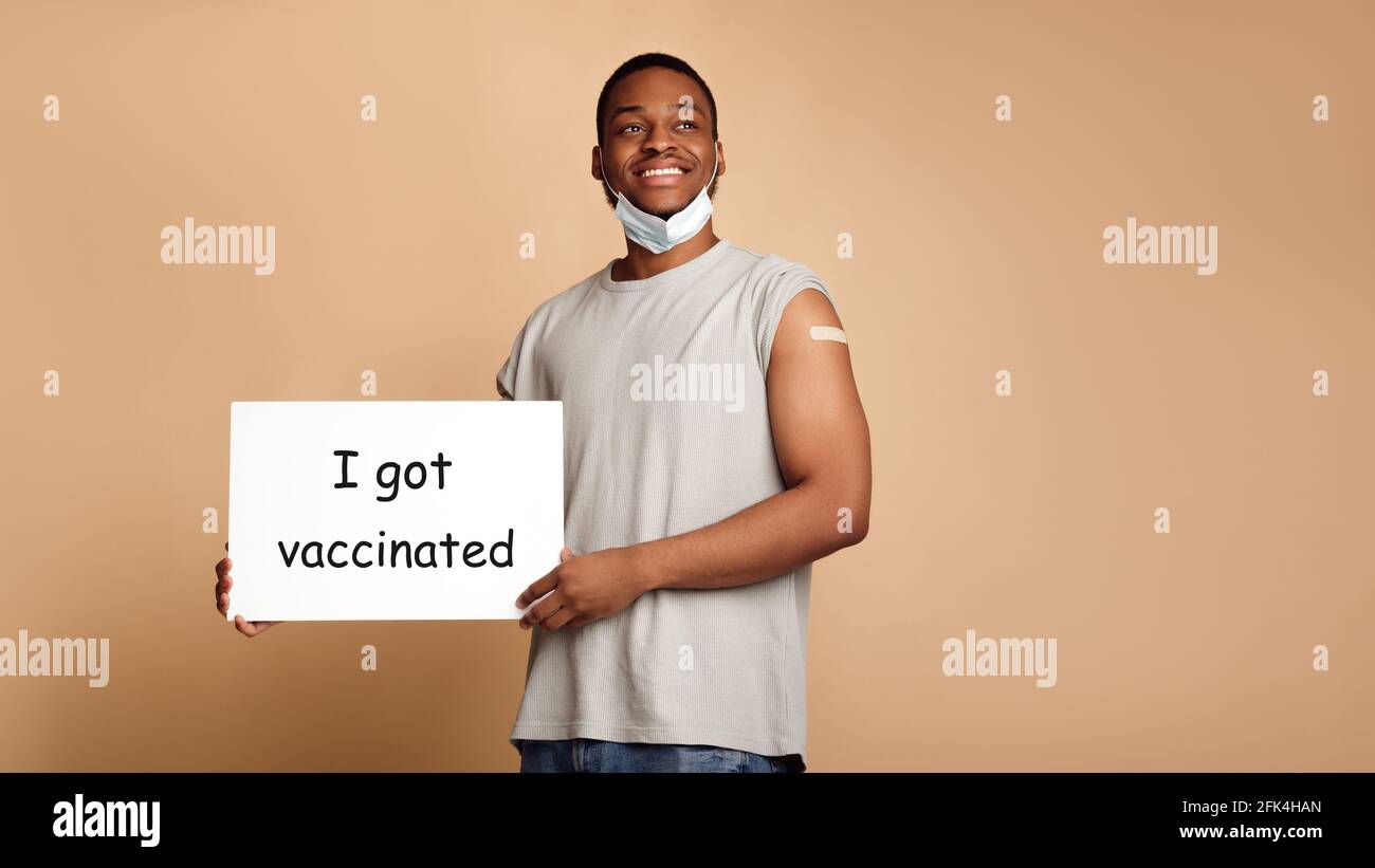 Hombre sosteniendo el cartel con texto Me vacuné, Beige fondo Foto de stock