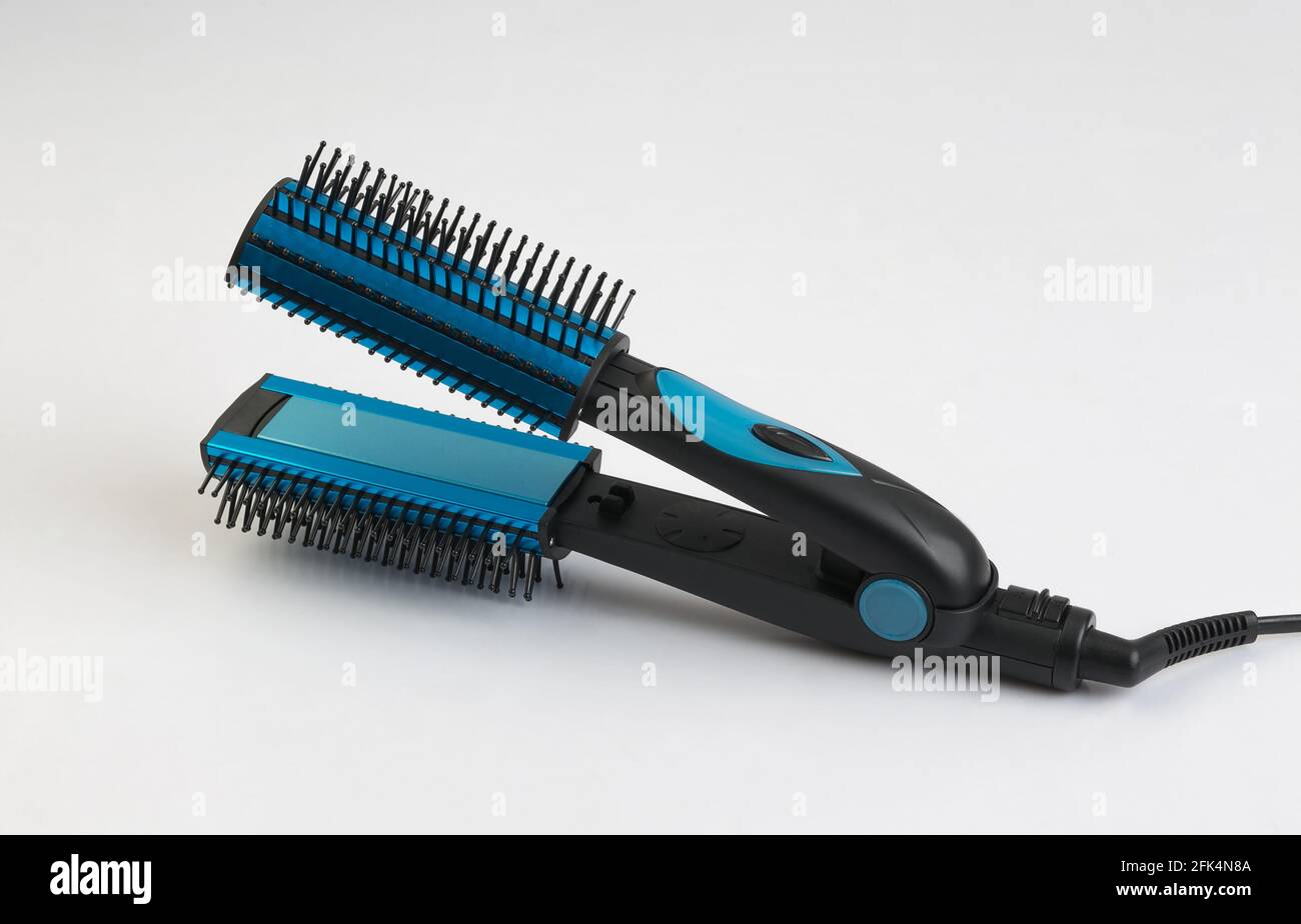 Plancha para el pelo azul con peine aislado sobre fondo blanco Fotografía  de stock - Alamy